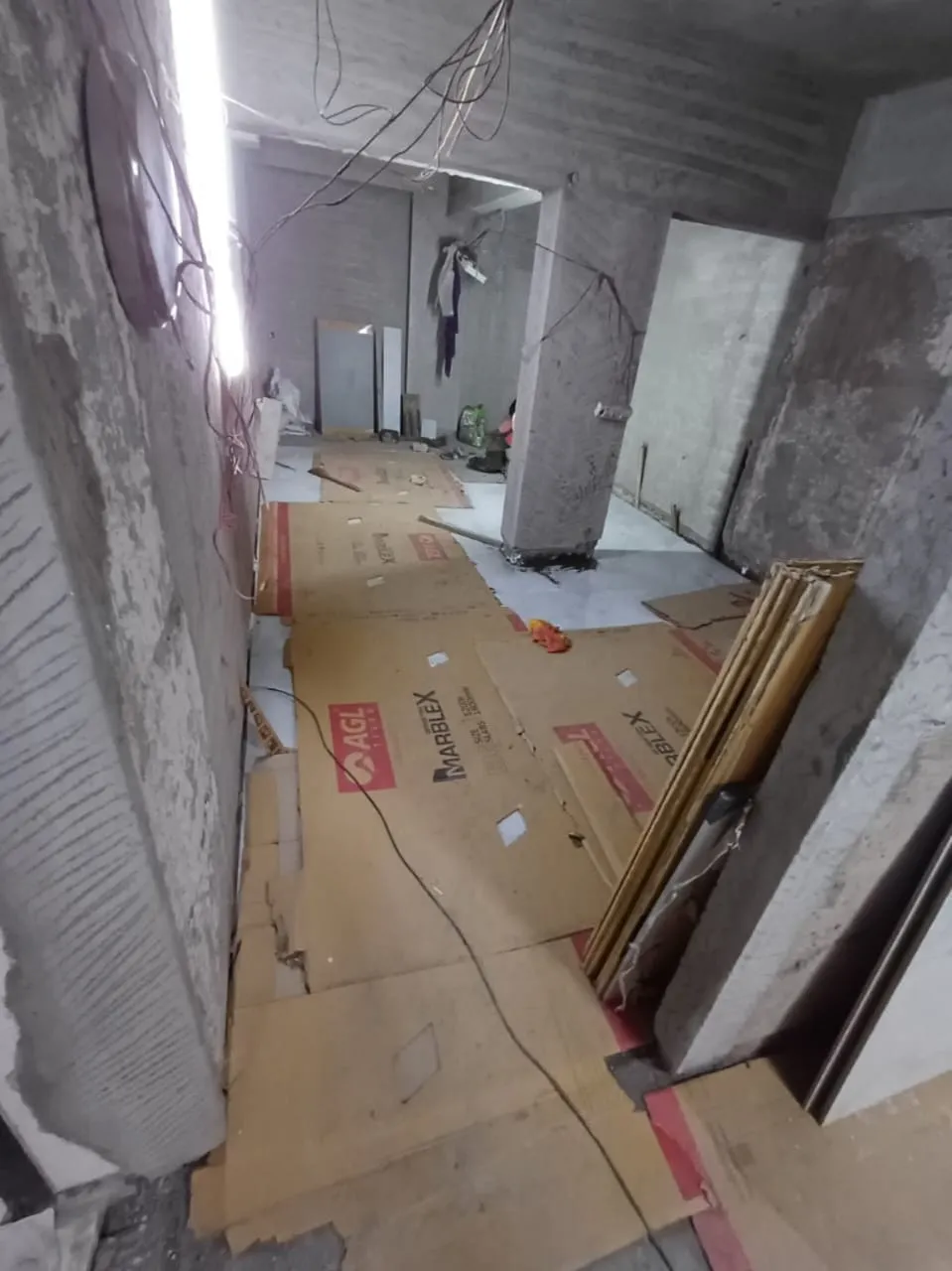 Floor tiling in progress with protective sheets on finished tiles